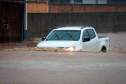 Carro andando em rua inundada