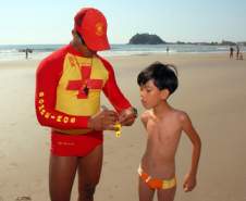 Bombeiros coloca pulseira de identificação em criança, na praia central de Guaratuba. Guaratuba, 22-12-2011.Foto: Arnaldo Alves / AENotícias.